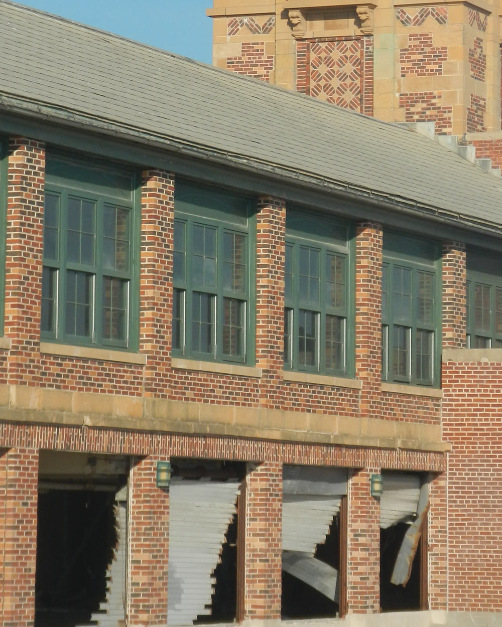 Ground-floor openings of a brick building left exposed after damage.